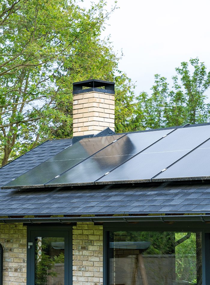 Close-up view of solar panels installed around a roof chimney