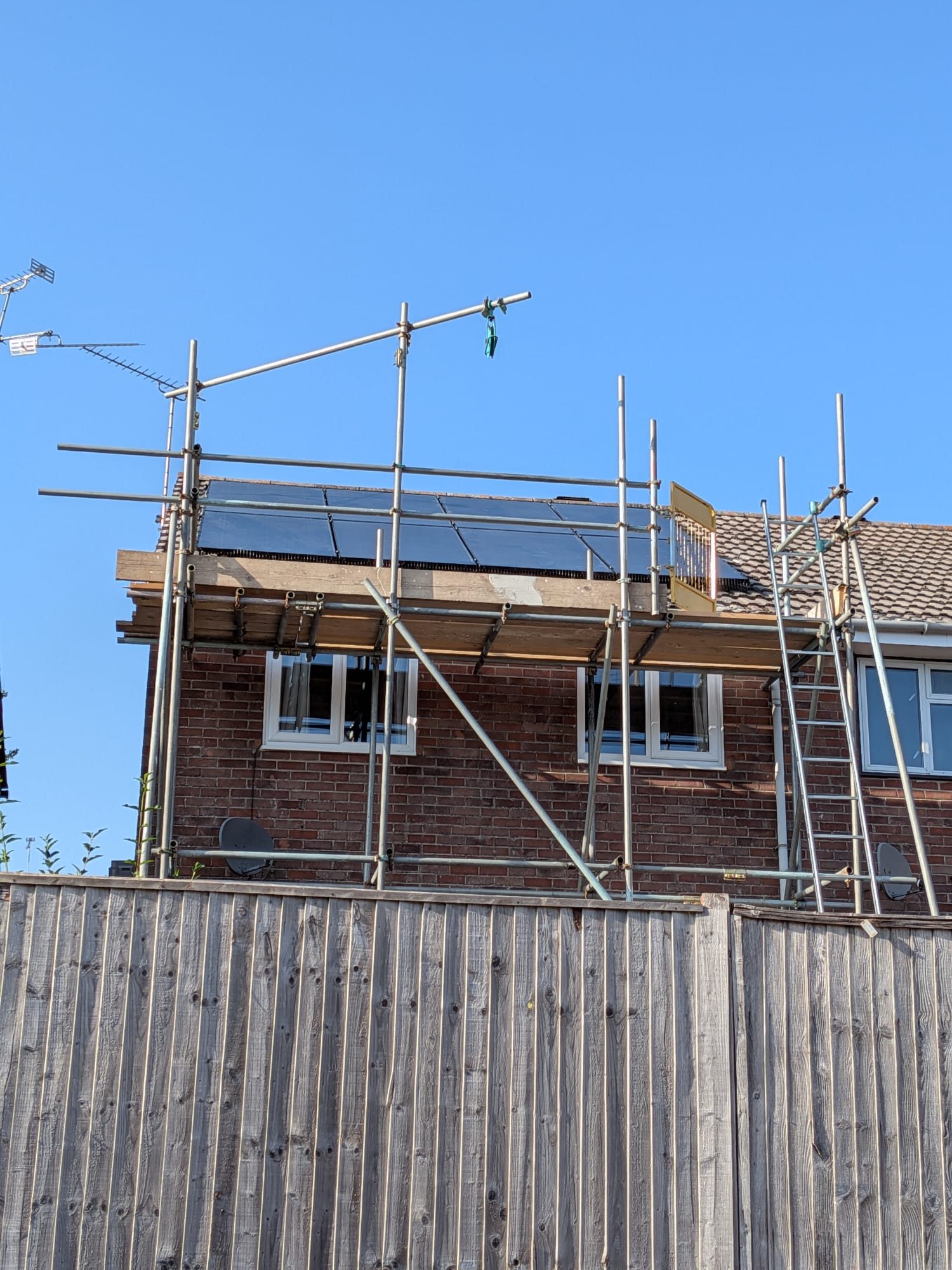 Completed solar panel array on a roof in Poole, scaffolding still in place