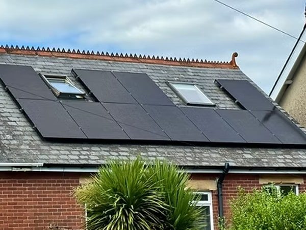 Full roof solar array fitted around two skylight windows on a red-brick home in Christchurch